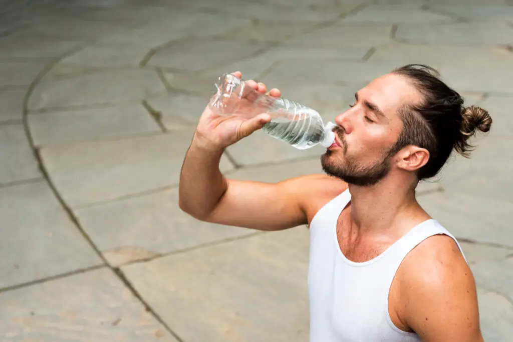 medium shot runner drinking water hydrated man
